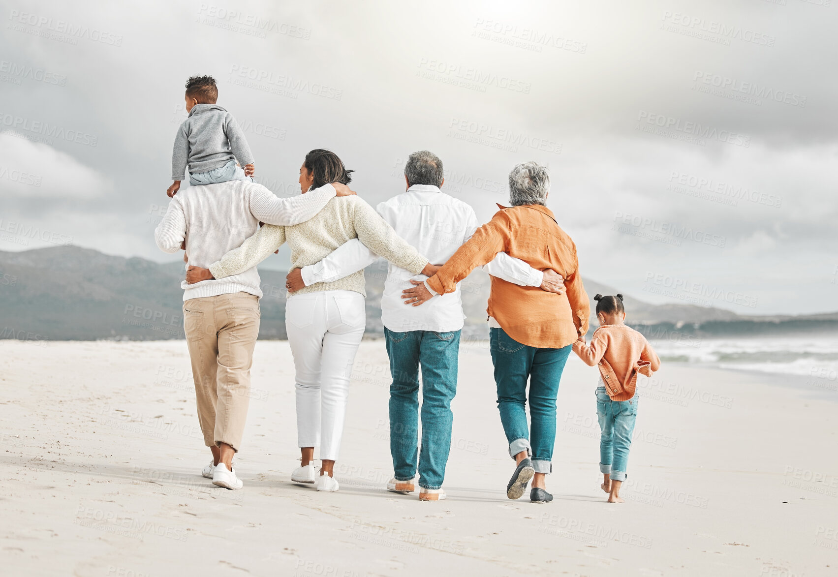 Buy stock photo Rearview shot of an affectionate family of six on the beach