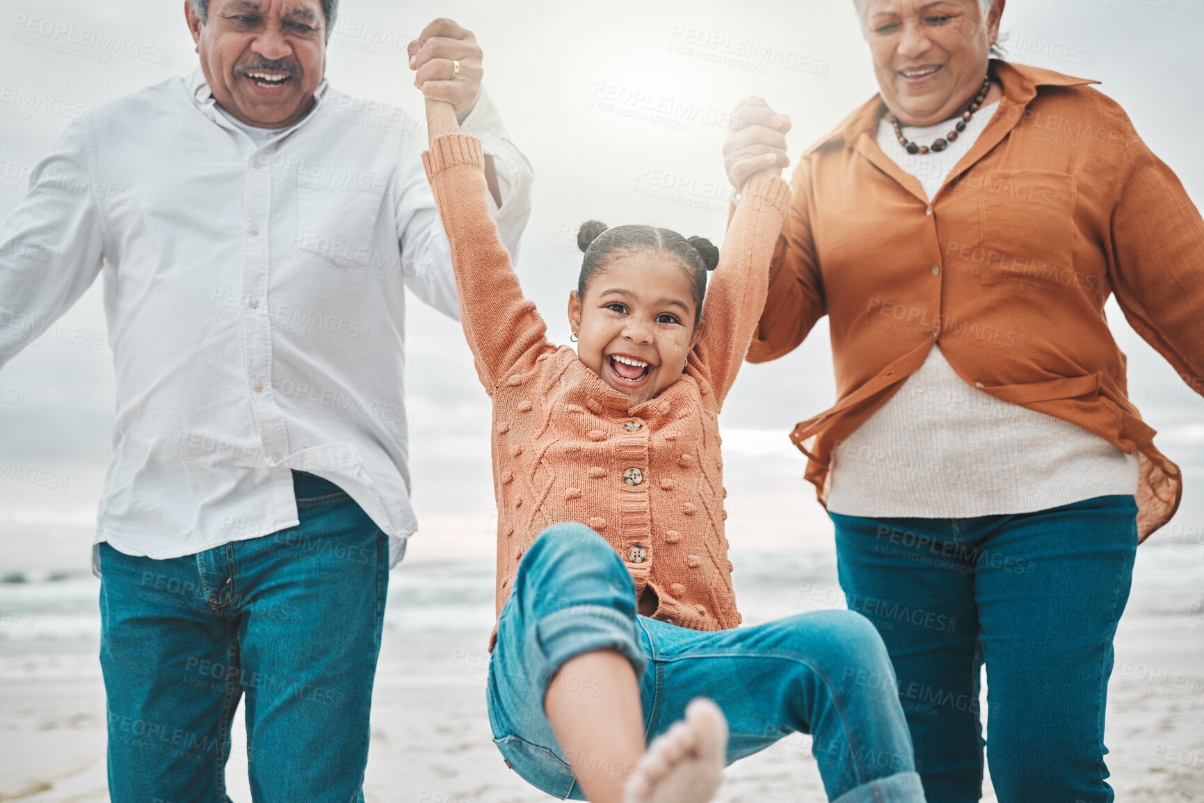 Buy stock photo Family, holding hands and portrait for games on beach, swinging and laugh on ocean holiday. Grandparents, bonding and love for sea waves in outdoor vacation, happiness and child together in nature