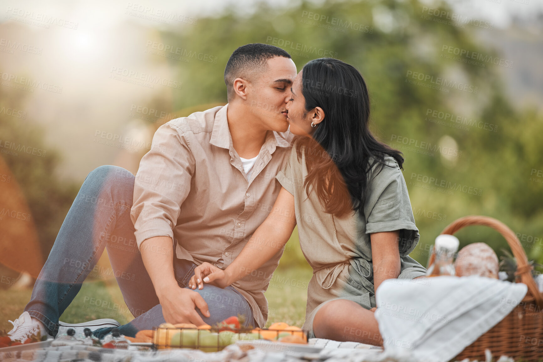 Buy stock photo Kiss, nature and couple on picnic for summer date on vacation, getaway or weekend trip. Love, fruit and young man and woman with connection, bonding and marriage honeymoon holiday in outdoor park.