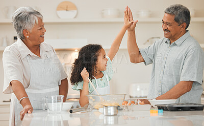 Buy stock photo Shot of two grandparents high fiving their grandchild while baking
