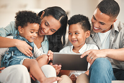 Buy stock photo Shot of a young family using a digital tablet together on the sofa at home