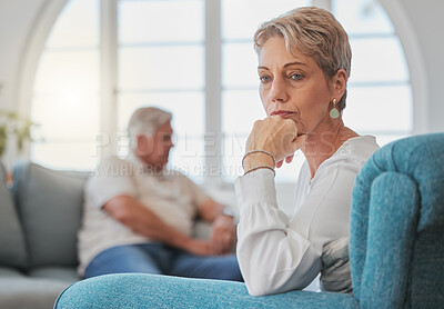 Buy stock photo Cropped shot of a senior couple looking sad and upset while sitting in their living room after an argument