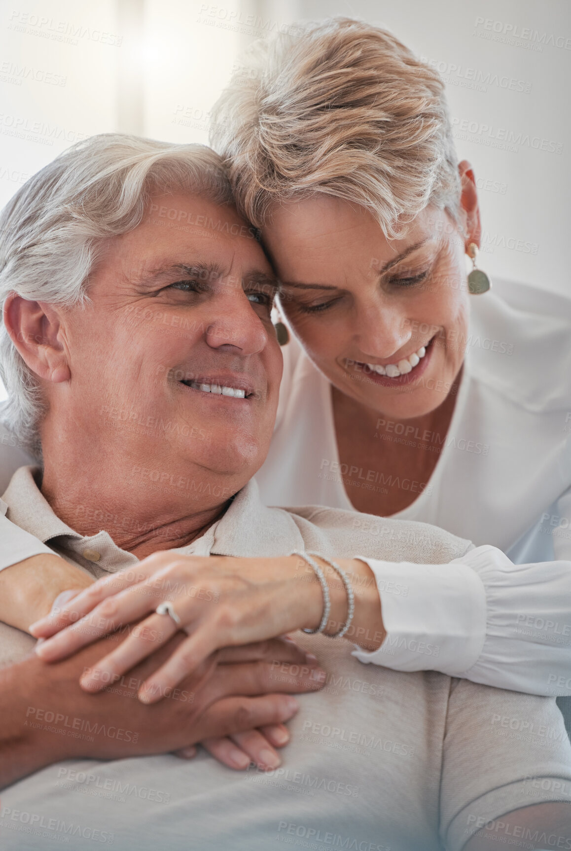 Buy stock photo Cropped shot of an affectionate senior couple relaxing in their living room at home