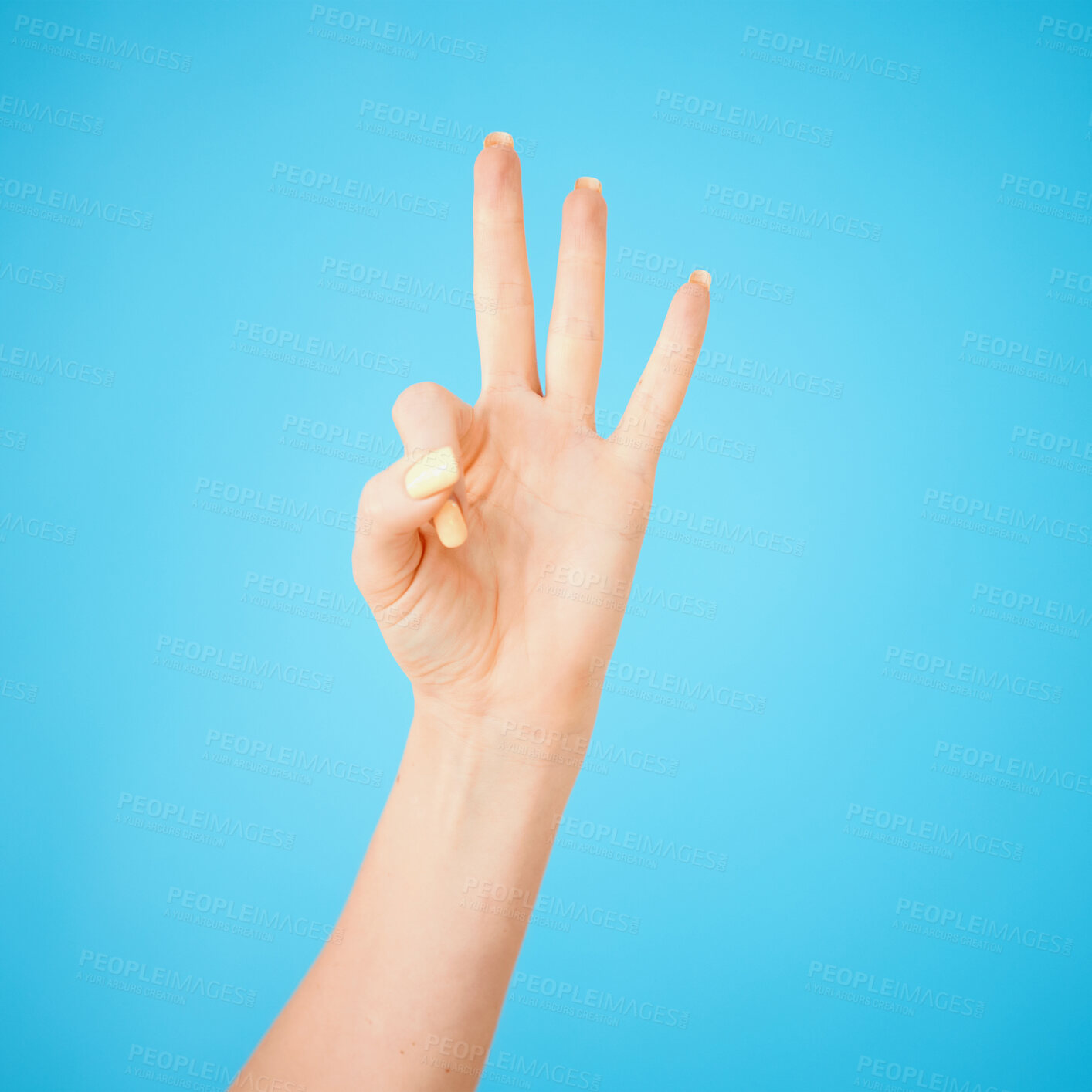 Buy stock photo Fingers, hand and three in studio on blue background for communication, counting or numbers. Countdown, gesture and palm with person isolated on color for emoji, sign language or signal space