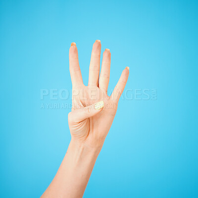 Buy stock photo Studio shot of an unrecognisable woman showing four fingers against a blue background