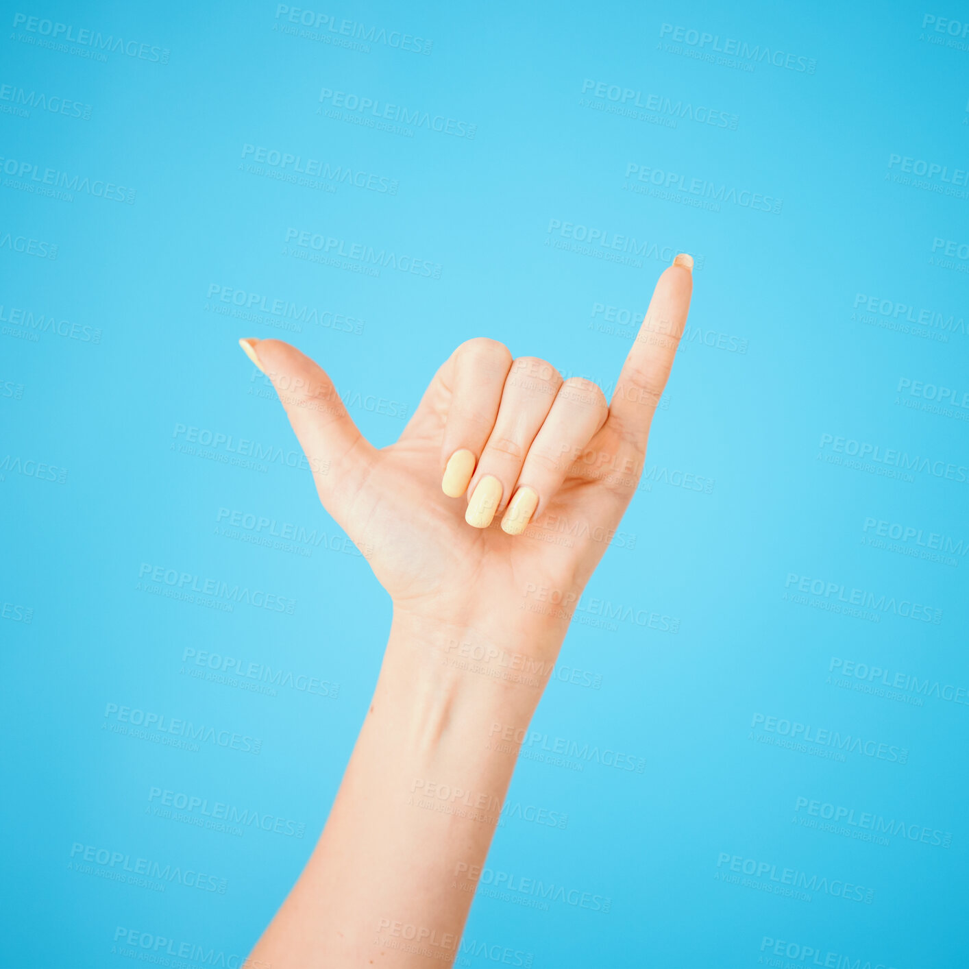 Buy stock photo Hand, gesture and shaka with model in studio on blue background feeling carefree closeup. Emoji, sign and signal with person greeting, cheer or winning surfing for good news or victory symbol