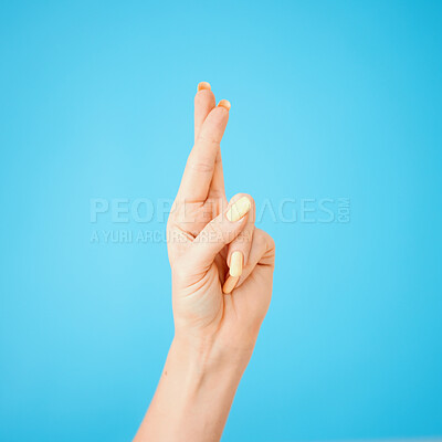 Buy stock photo Excited, hope and model with fingers crossed isolated on blue studio background. Happy, trust and person with wish, waiting sign and hand gesture for winning or future achievement or luck emoji