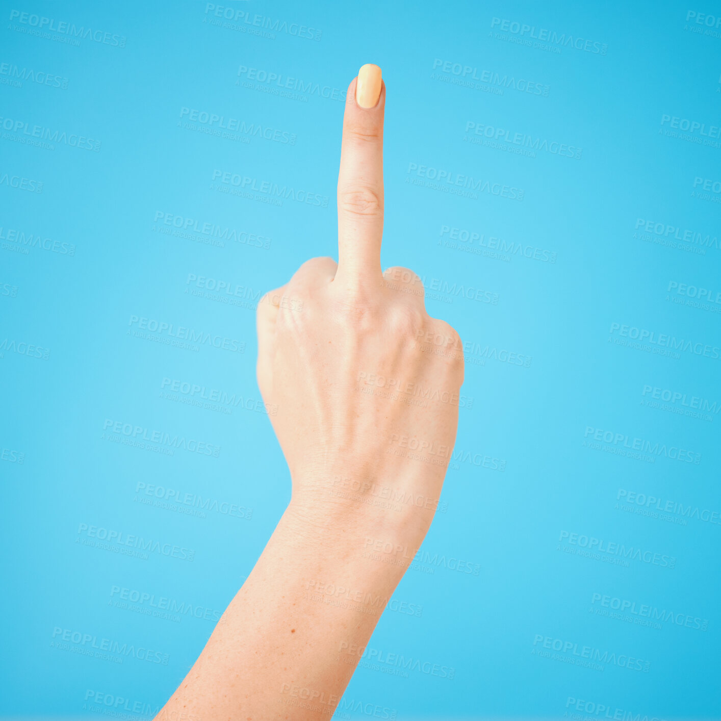Buy stock photo Studio shot of an unrecognisable woman showing her middle finger against a blue background