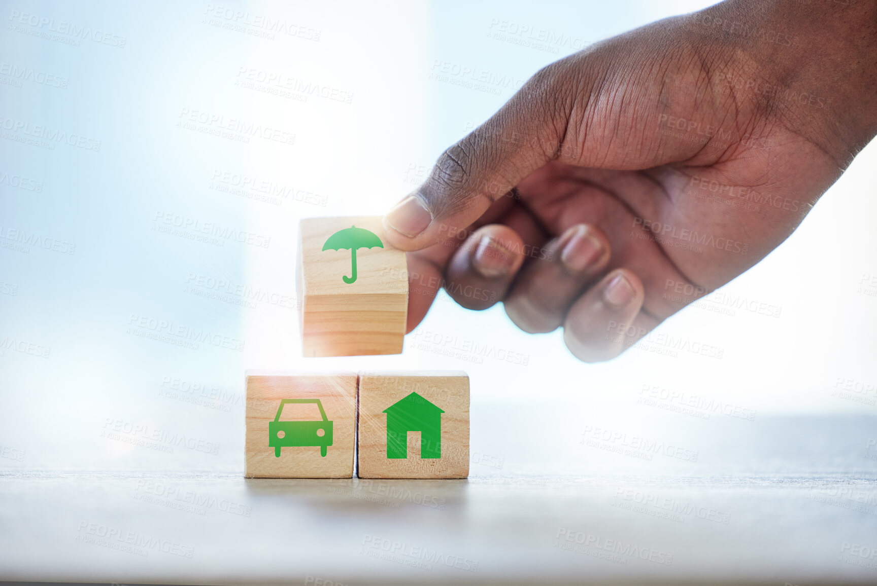 Buy stock photo Hand, building blocks and protection with insurance in office with security for assets, property and car. Person, agent and wood toys with choice, service or umbrella icon for risk cover at company