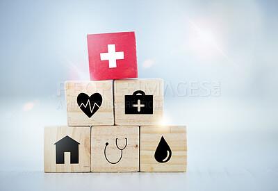 Buy stock photo Healthcare, insurance and medicine with building blocks on desk in hospital for future planning or wellness. Life, pyramid and stack with symbol icons in clinic for medical cover, finance or security