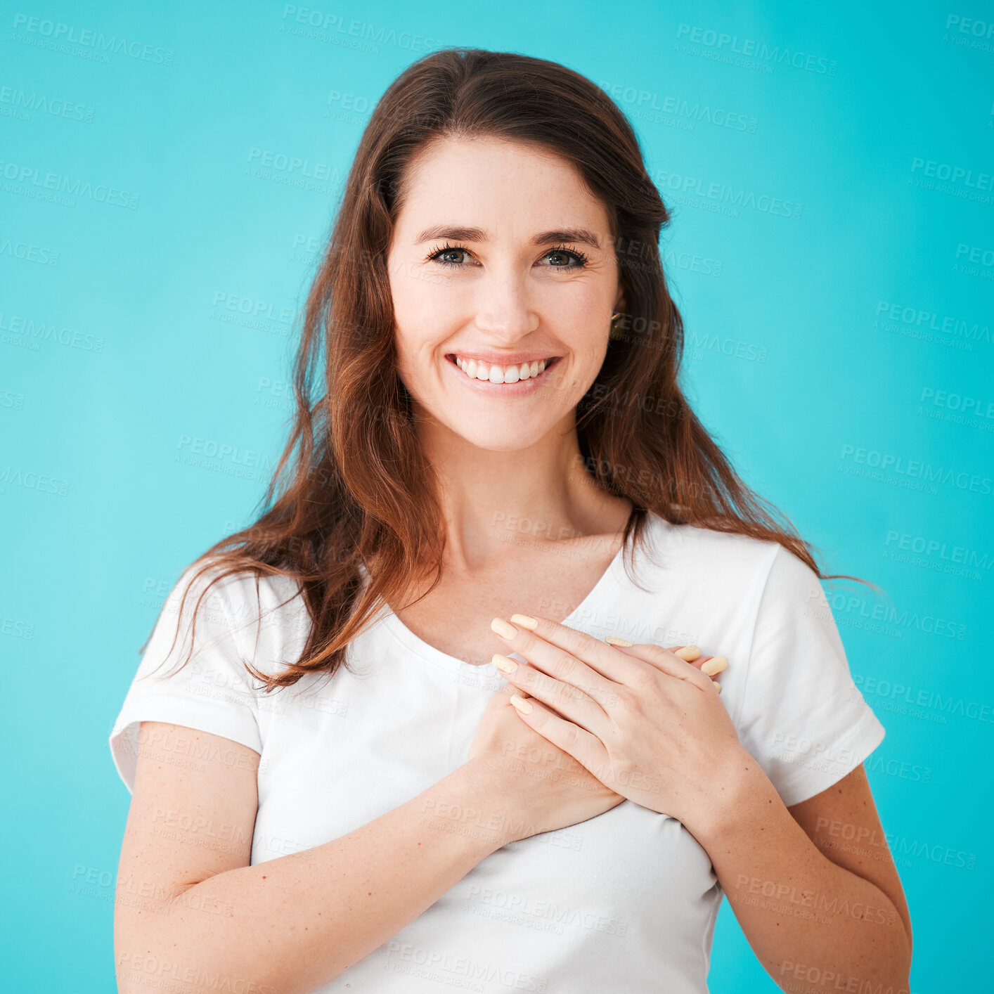 Buy stock photo Woman, portrait and hands on chest in studio for thank you, kindness and compassion with smile. Appreciation, person and empathy gesture for gratitude, acceptance and compliment on blue background