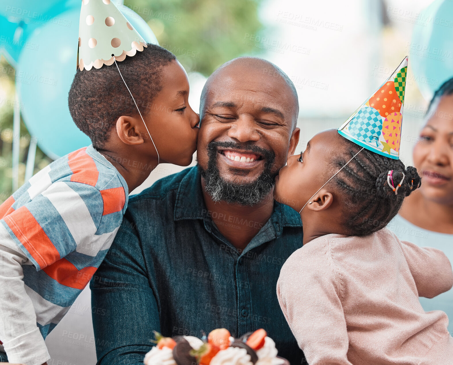 Buy stock photo Shot of two children kissing a mature man on his cheeks during a birthday party