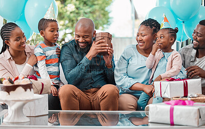Buy stock photo Shot of a man shaking a box he received at his birthday party