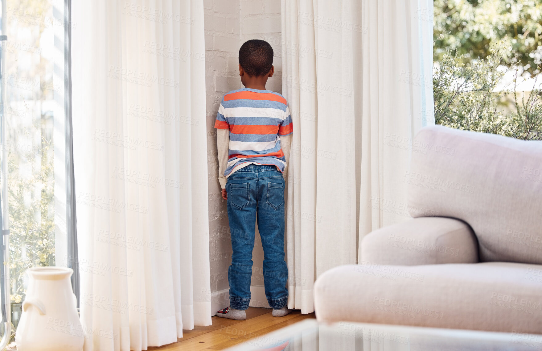 Buy stock photo Home, back and child in naughty corner for punishment in living room with behavior problem. Wall, attitude and boy kid in timeout for discipline of attitude, tantrum or mistake in lounge at house.