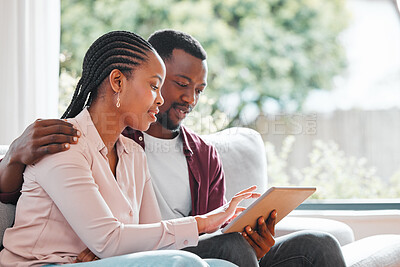 Buy stock photo Shot of a young couple relaxing at home using a digital tablet