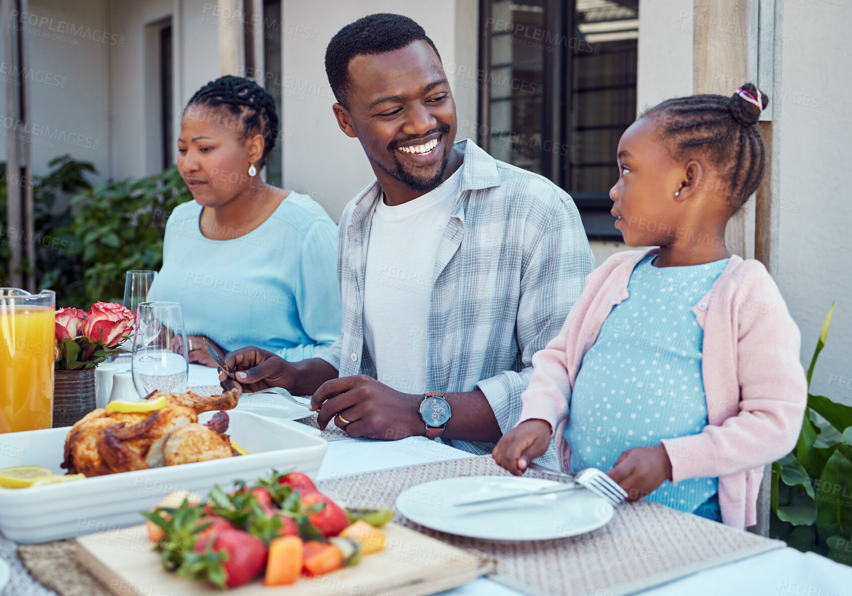 Buy stock photo Black family, lunch and people with child by home for eating, conversation and relax together at reunion. African man, happy and love at table in backyard for meal, nutrition and bonding on weekend