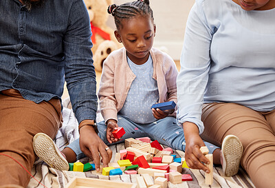 Buy stock photo Shot of a little girl playing with blocks with her grandparents at home