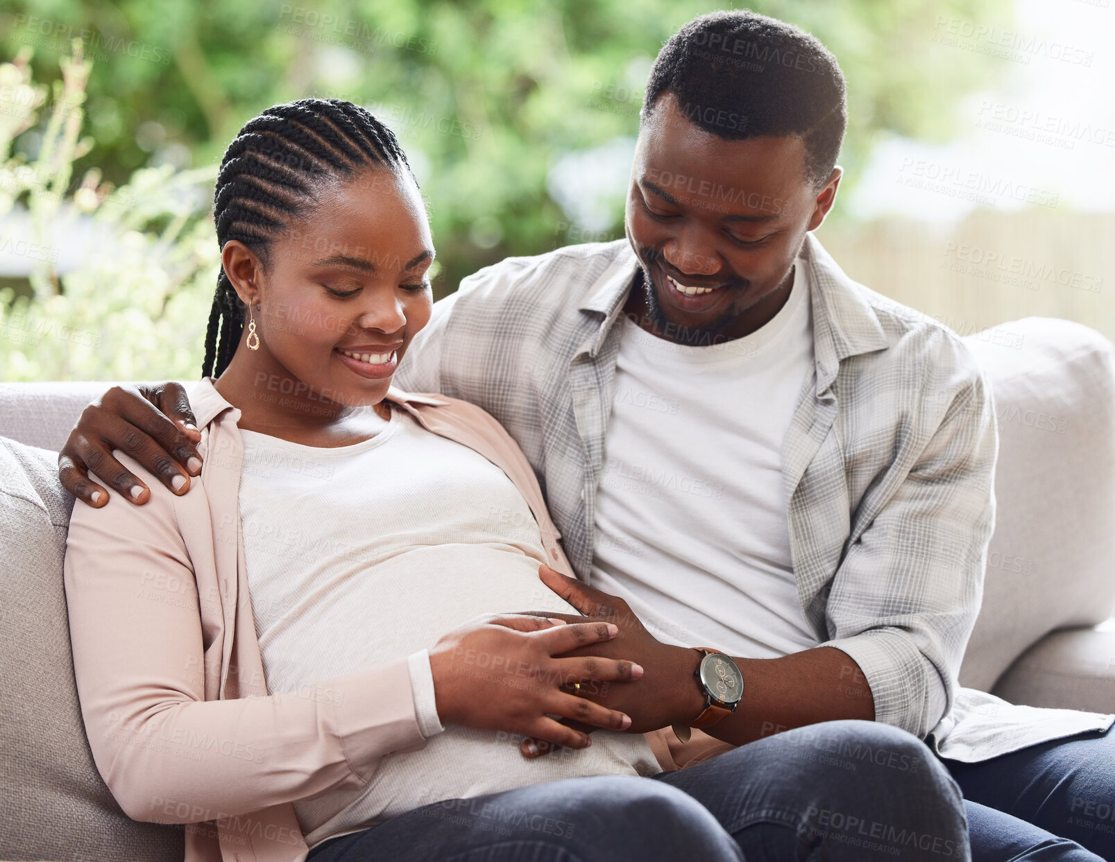 Buy stock photo Black couple, pregnant and hand on stomach for love, support and feeling baby kick in home. Future parents, hug and touch belly on patio for growth, maternity and commitment in relationship with care