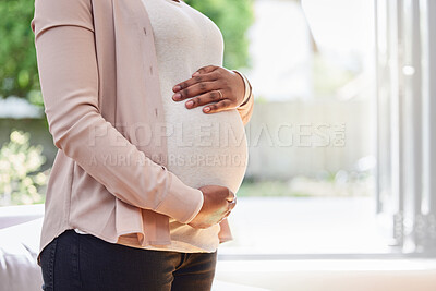 Buy stock photo Cropped shot of an unrecognizable mother to be standing in her living room at home