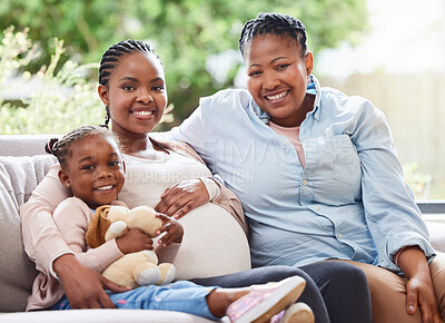 Buy stock photo Cropped portrait of an attractive young pregnant woman sitting on the sofa at home with her mother and daughter
