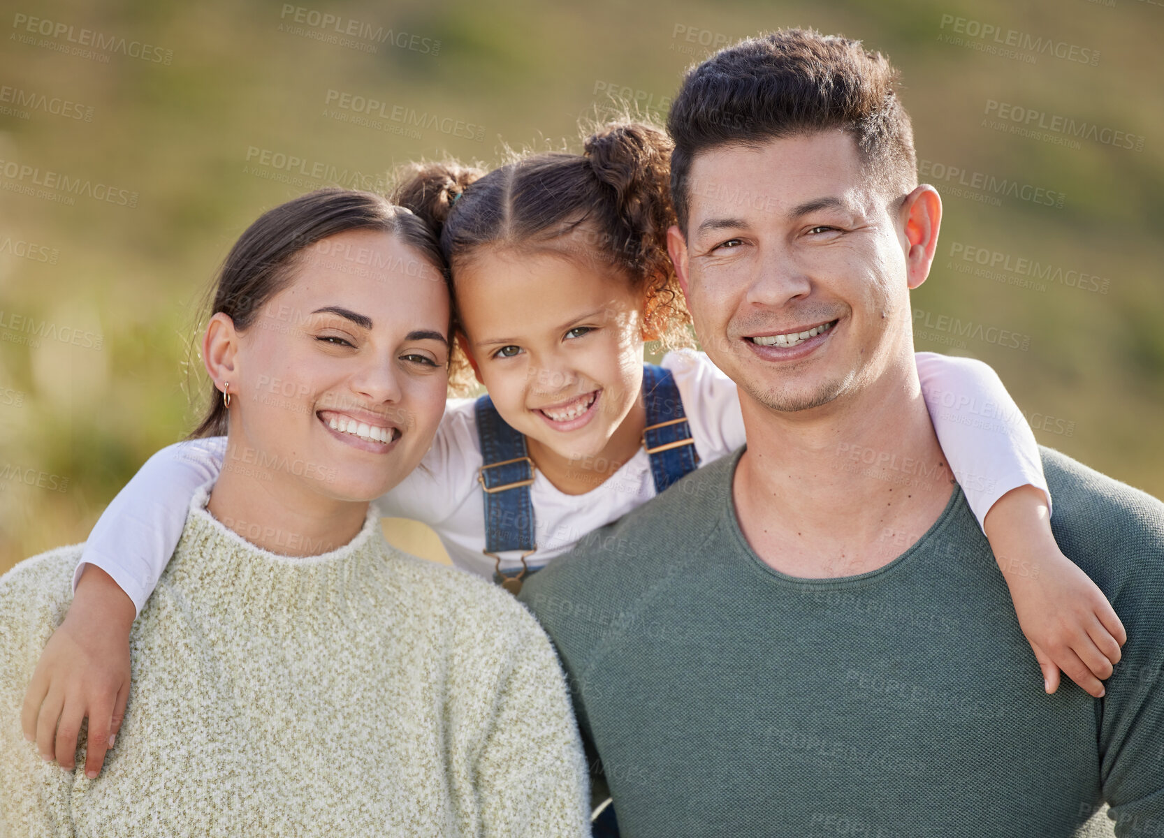 Buy stock photo Shot of a young couple spending time outdoors with their daughter