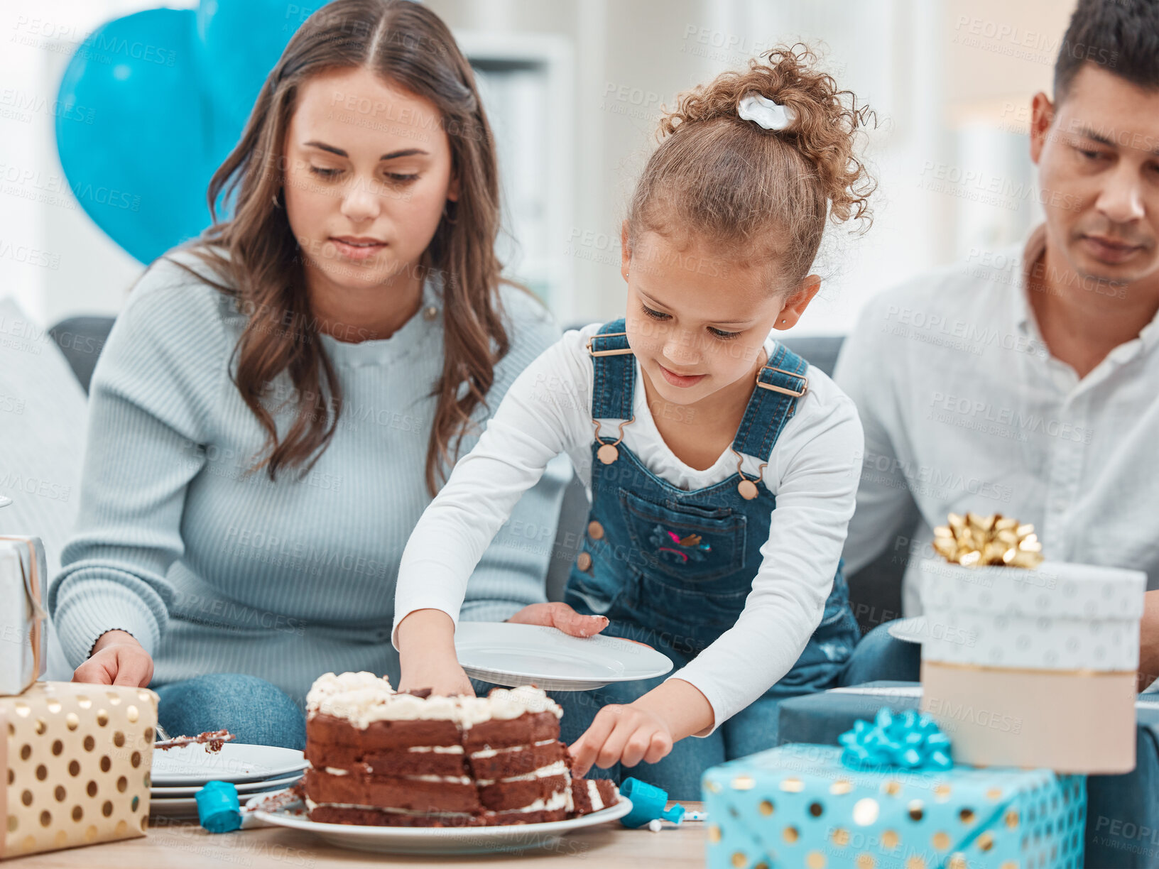 Buy stock photo Birthday, cake and serve with family in living room for celebration, balloons and milestone event. Gift giving, love and support with people and party at home for growth, care and gathering.