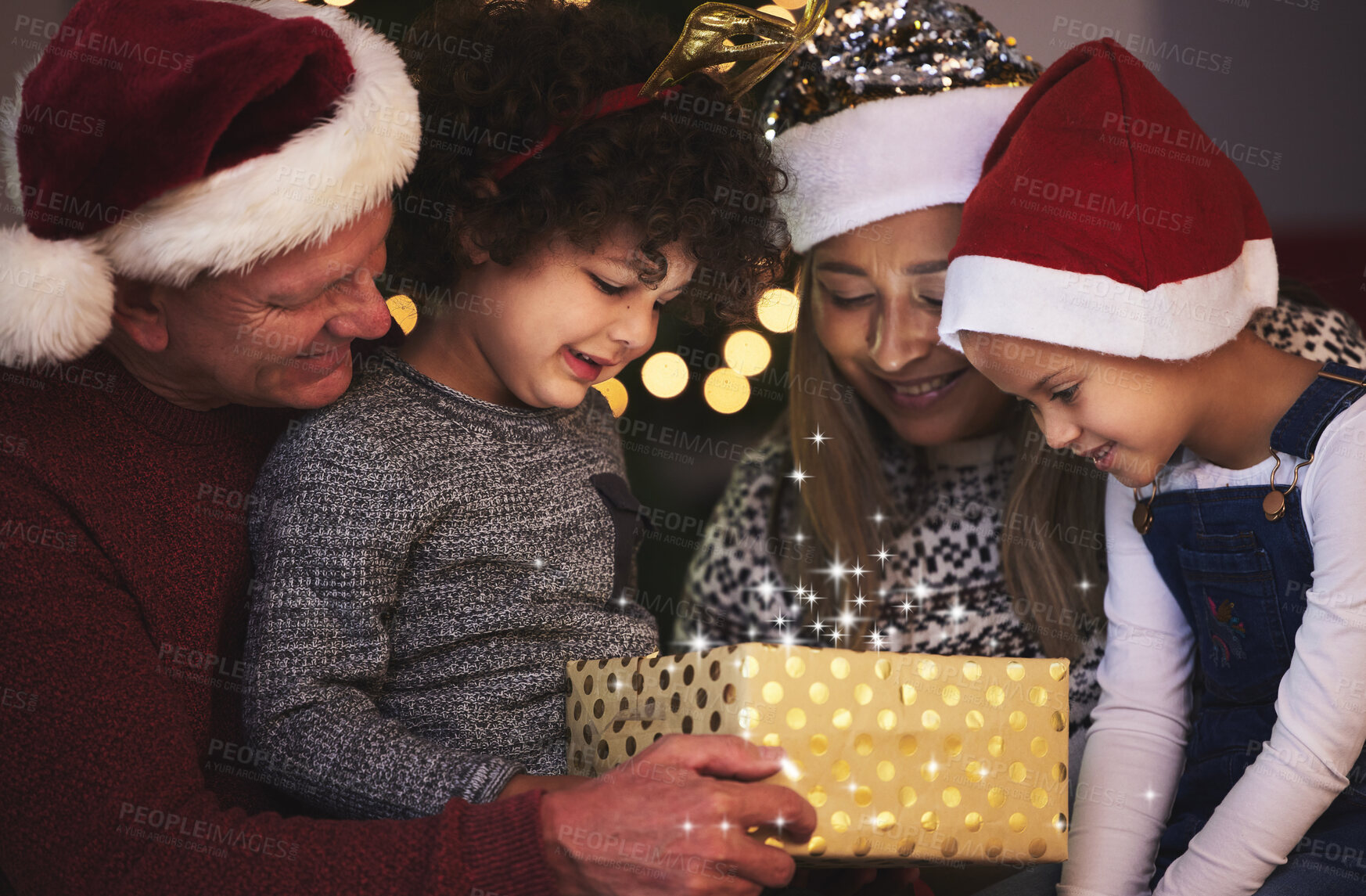 Buy stock photo Shot of a family opening a Chrstmas gift together at home