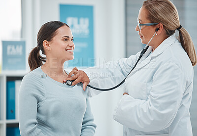 Buy stock photo Shot of a doctor examining a patient with a stethoscope during a consultation in a clinic
