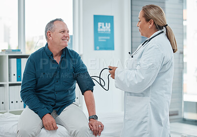 Buy stock photo Senior, happy man and doctor with patient for blood pressure, checkup or heart rate at hospital. Mature, male person and medical professional with smile on clinic bed for examination, test or results