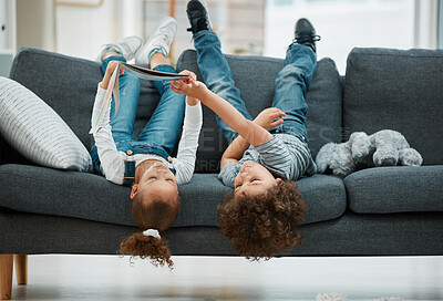 Buy stock photo Shot of two siblings reading a book together