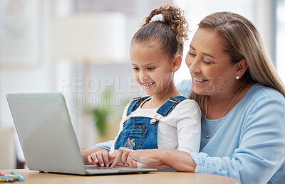 Buy stock photo Shot of a little girl and her grandmother using a laptop together at home