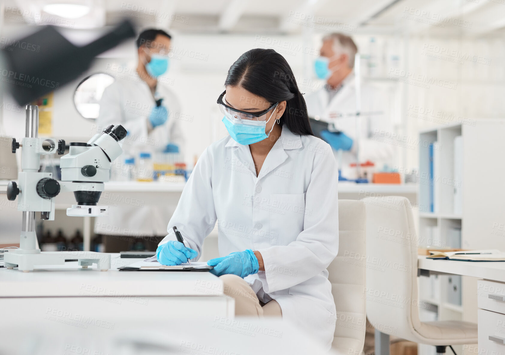 Buy stock photo Lab, writing and microscope research for vaccine study and mask for virus analysis with notes. Woman, scientist and ppe for protection with medical journal and experiment with biotechnology testing