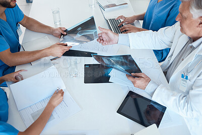 Buy stock photo Shot of a group of medical staff in a meeting looking at x-rays