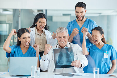 Buy stock photo Shot of a team of medical staff cheering while looking at an x-ray