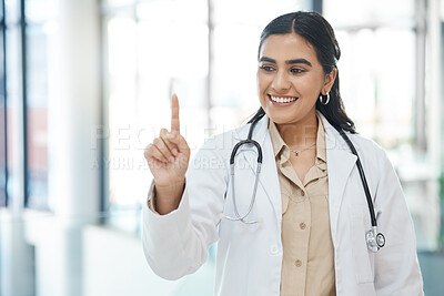 Buy stock photo Shot of a young female doctor holding up her finger in a hospital