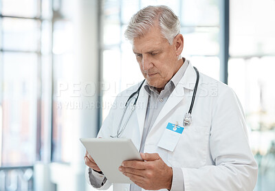 Buy stock photo Shot of a doctor using a tablet in a hospital
