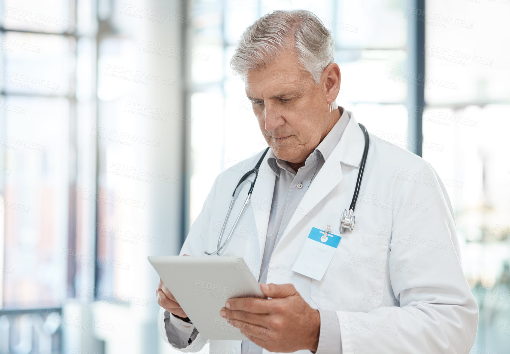 Buy stock photo Typing, mature man and doctor with tablet, app and internet with connection in hospital. Person, medical and professional in clinic, tech and research for diagnosis, online schedule and healthcare