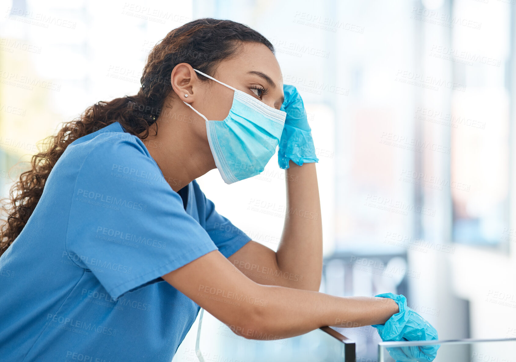 Buy stock photo Shot of a female nurse looking stressed while standing in a hospital