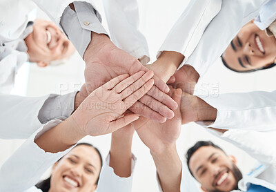 Buy stock photo Shot of a group of medical practitioners joining their hands together in a huddle