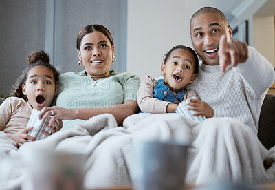 Buy stock photo Shot of a happy family eating popcorn while watching television together at home