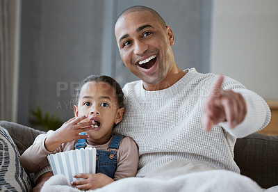 Buy stock photo Shot of a father and daughter eating popcorn while watching television together at home