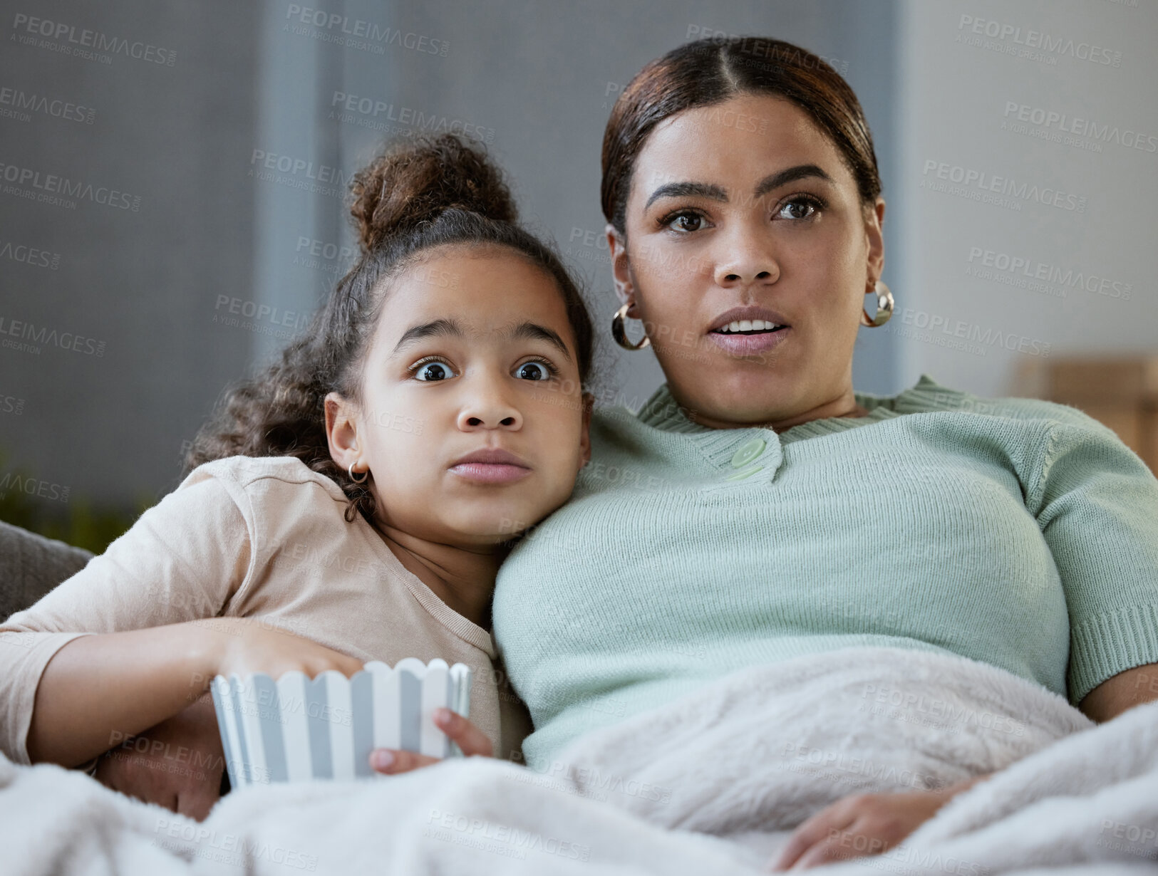 Buy stock photo Mom, girl and scared on sofa with movie, popcorn and wow with bonding, horror and television in lounge. Woman, mother and daughter with eating, fear and streaming in family house for film in Mexico