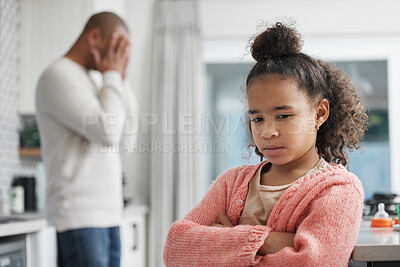 Buy stock photo Shot of a little girl looking unhappy after a disagreement with her father at home