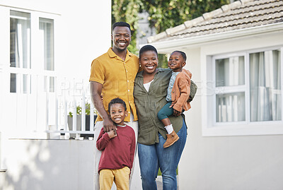 Buy stock photo Shot of a couple standing in front of a house with their two children