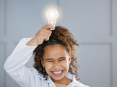 Buy stock photo Cropped shot of an adorable little girl wearing a labcoat and holding a lightbulb above her head