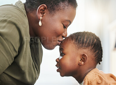 Buy stock photo Shot of a young mother kissing her daughter on her forehead