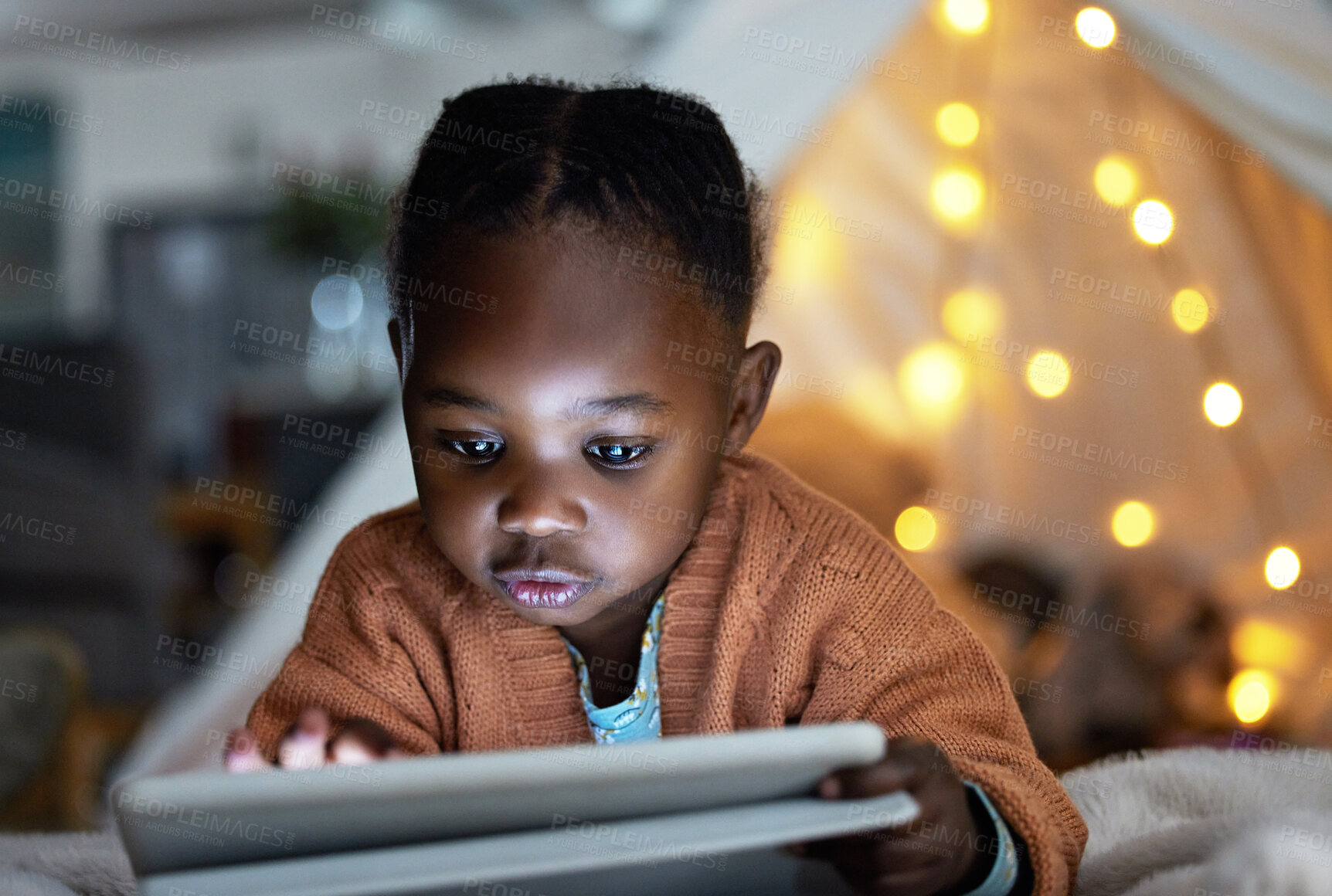 Buy stock photo Black, girl and tablet to relax at night for streaming story online, watch movie and website for game in tent bedroom. African, child and scroll with digital for cartoon subscription at house