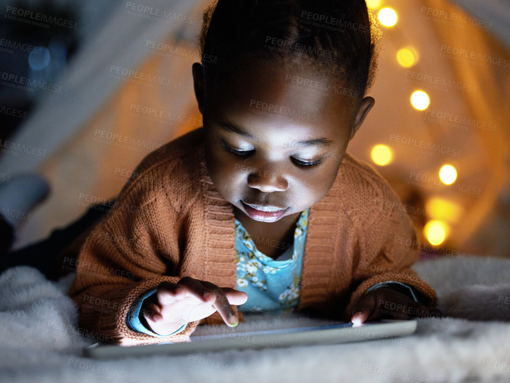 Buy stock photo Relax, black and girl with tablet at night for streaming story online, watch movie and website for game in tent bedroom. African, child and scroll with digital for cartoon subscription at house