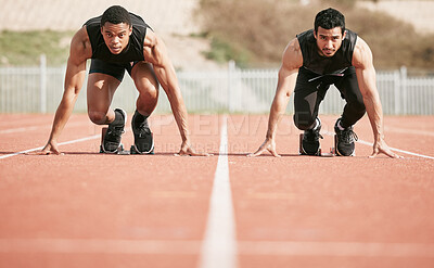 Buy stock photo Full length shot of two handsome young male athletes starting their race on a track