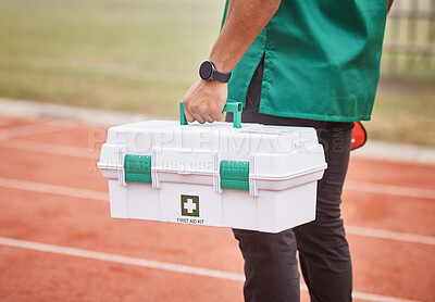 Buy stock photo Rearview shot of an unrecognizable male paramedic standing outside on a track with his first aid kit